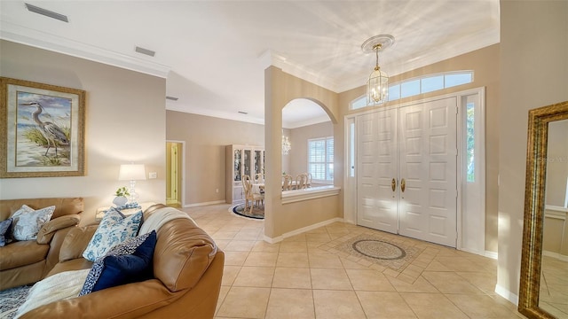 tiled entryway with an inviting chandelier and ornamental molding