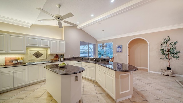 kitchen featuring white cabinetry, sink, dark stone counters, and a kitchen island