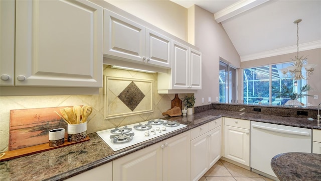 kitchen with white cabinetry, light tile patterned floors, white appliances, and dark stone countertops