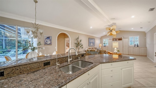 kitchen with dark stone counters, sink, hanging light fixtures, and white cabinets