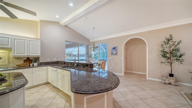 kitchen with light tile patterned flooring, kitchen peninsula, sink, and lofted ceiling with beams