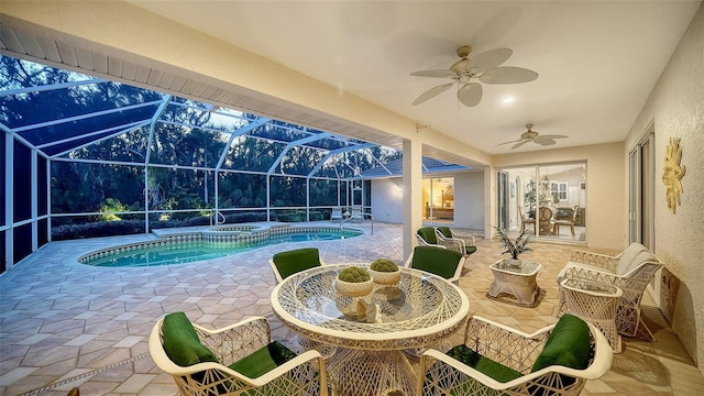 view of swimming pool featuring an in ground hot tub, a lanai, ceiling fan, and a patio area