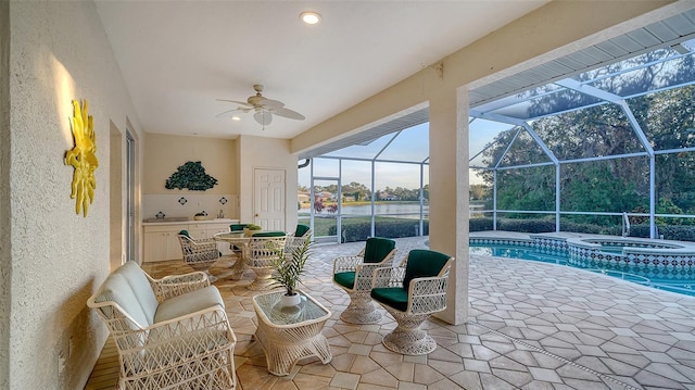 view of patio / terrace with ceiling fan, glass enclosure, and a pool with hot tub