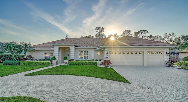 view of front of property featuring a garage and a lawn