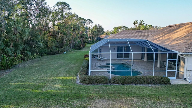 exterior space featuring a swimming pool with hot tub, a patio area, glass enclosure, and a lawn