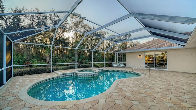 view of swimming pool with a lanai, a patio, and an in ground hot tub