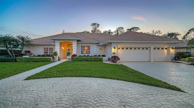 view of front of property with a tiled roof, decorative driveway, and stucco siding