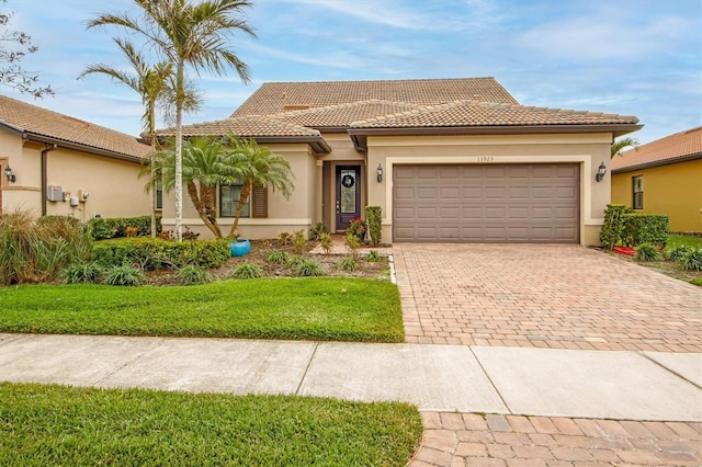 mediterranean / spanish-style house with a garage and a front lawn