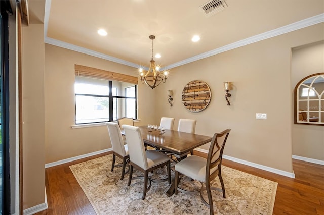 dining area featuring a notable chandelier, crown molding, and dark hardwood / wood-style floors