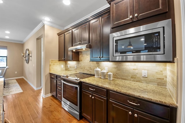 kitchen featuring backsplash, ornamental molding, stainless steel appliances, dark brown cabinets, and light wood-type flooring