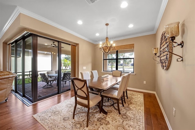 dining space with hardwood / wood-style flooring, crown molding, and a healthy amount of sunlight