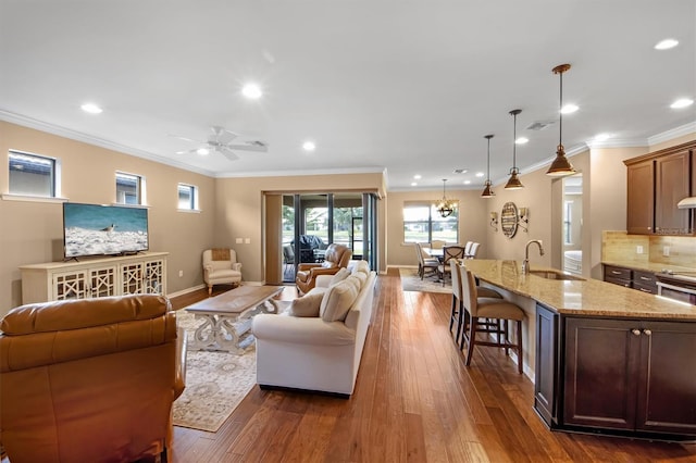 living room featuring crown molding, sink, ceiling fan, and dark hardwood / wood-style floors