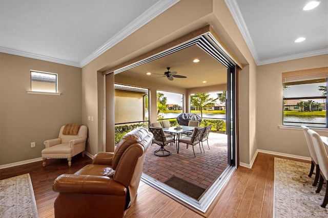 doorway to outside featuring hardwood / wood-style flooring, ornamental molding, and a water view