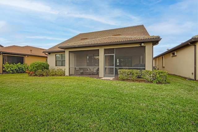 rear view of property featuring a lawn and a sunroom