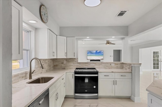 kitchen with sink, stainless steel appliances, white cabinets, and light stone countertops