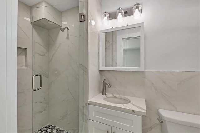 bathroom with vanity, tile walls, an enclosed shower, and toilet