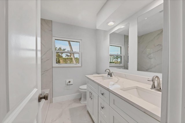 bathroom with vanity, toilet, a shower, and a wealth of natural light