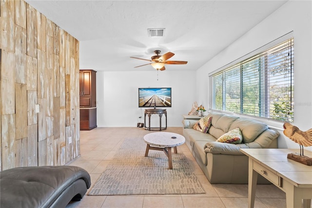 tiled living room with a textured ceiling and ceiling fan