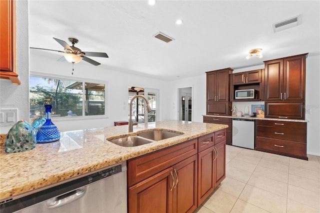 kitchen with appliances with stainless steel finishes, sink, light tile patterned floors, ceiling fan, and light stone countertops