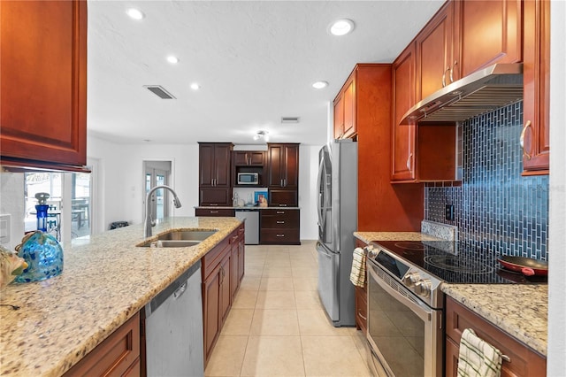 kitchen with sink, light tile patterned floors, appliances with stainless steel finishes, backsplash, and light stone countertops