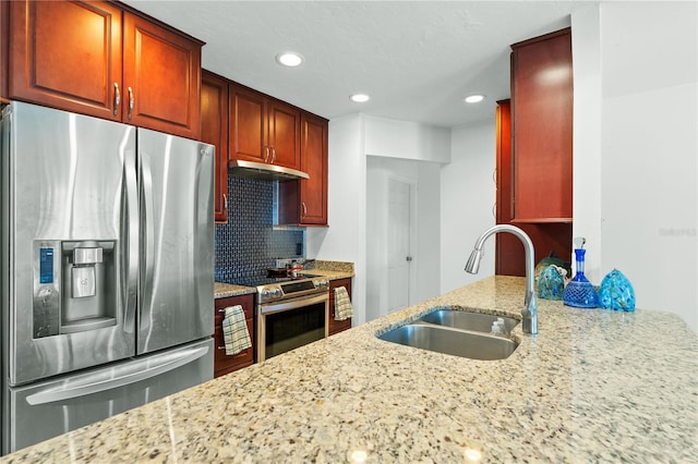 kitchen with stainless steel appliances, light stone countertops, sink, and backsplash