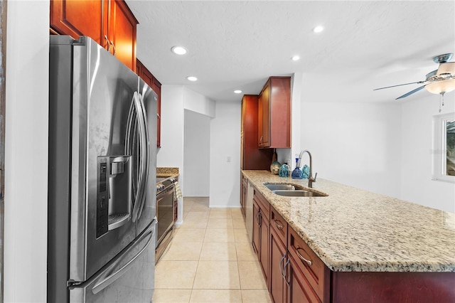 kitchen with light tile patterned flooring, sink, appliances with stainless steel finishes, kitchen peninsula, and light stone countertops