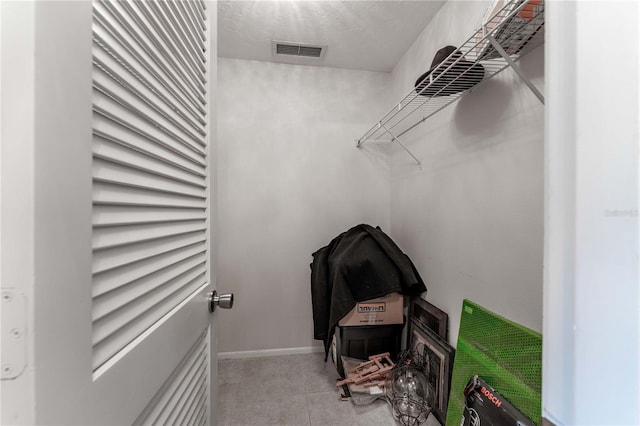 walk in closet featuring light tile patterned flooring