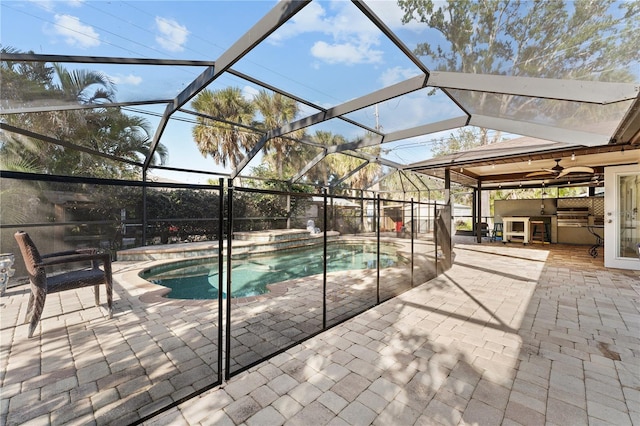 view of pool with a patio, an outdoor kitchen, and a lanai