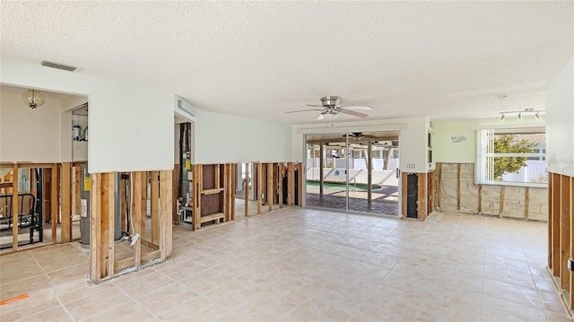 unfurnished room with a textured ceiling and ceiling fan