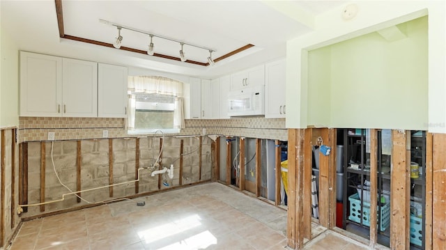 kitchen with white cabinetry and a tray ceiling