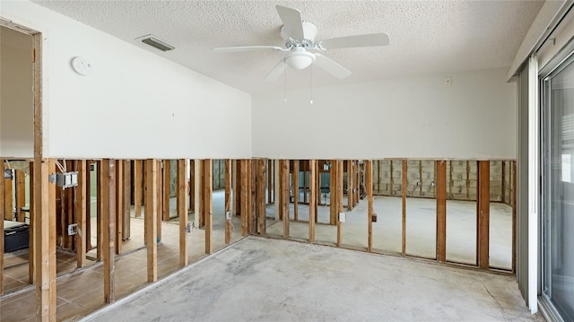 misc room featuring ceiling fan, a textured ceiling, and concrete floors