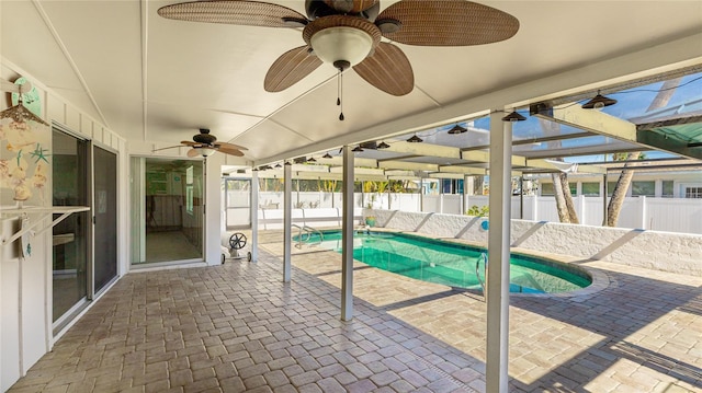 view of pool with glass enclosure, ceiling fan, and a patio area