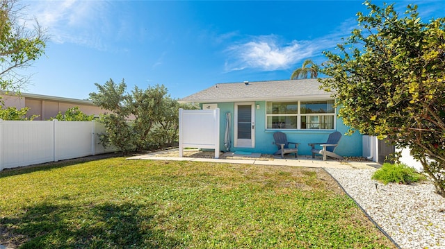 rear view of house featuring a lawn