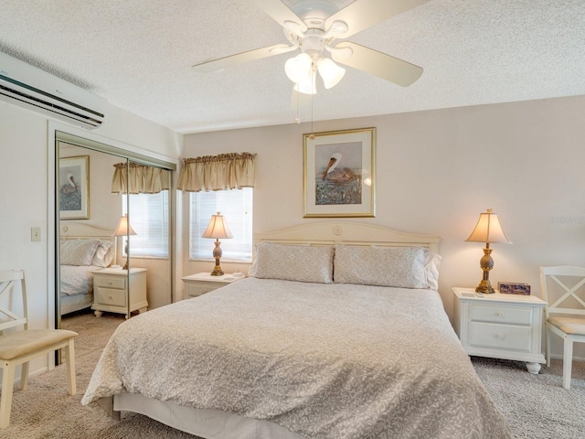 carpeted bedroom featuring ceiling fan, a wall mounted AC, a textured ceiling, and a closet