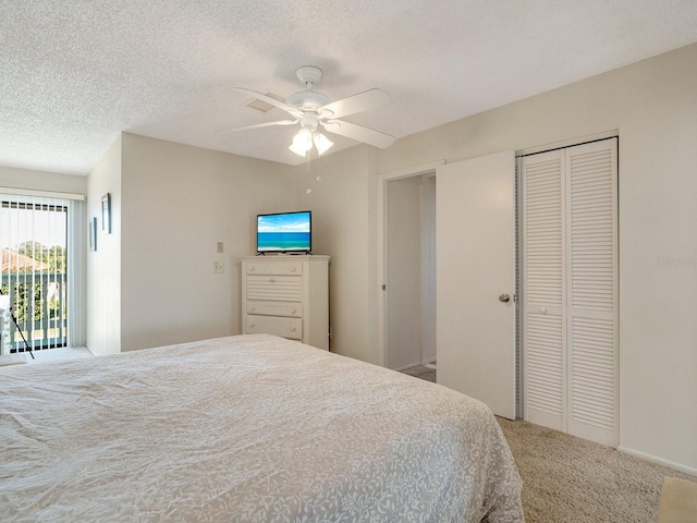 bedroom with ceiling fan, a closet, carpet, and a textured ceiling