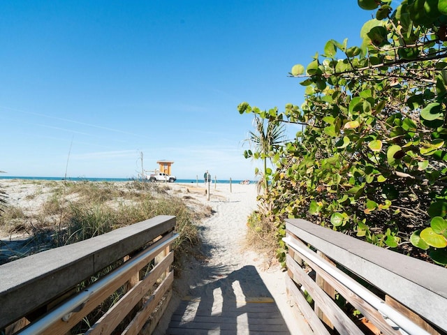 surrounding community with a water view and a beach view