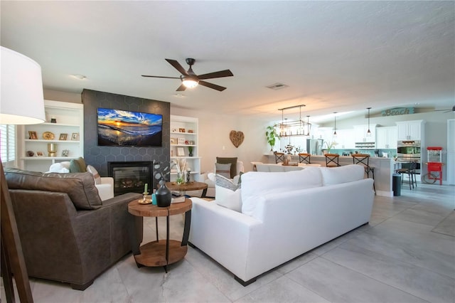 living room with ceiling fan and a fireplace