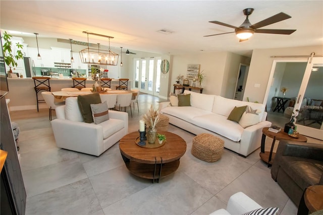 living room with ceiling fan with notable chandelier