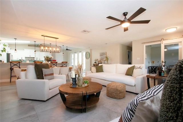 living room featuring ceiling fan with notable chandelier