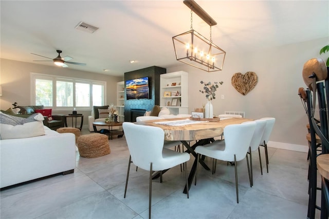 dining space with a fireplace and ceiling fan