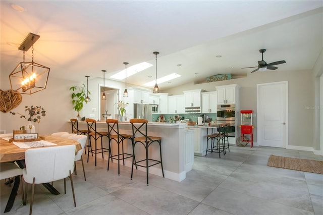 kitchen featuring stainless steel appliances, a large island, pendant lighting, and white cabinets