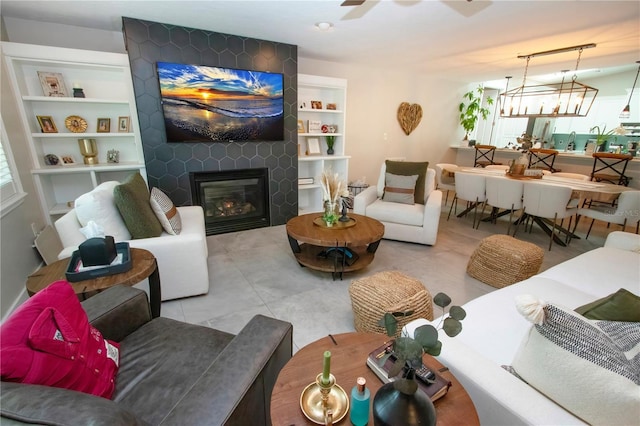 living room featuring a large fireplace and ceiling fan