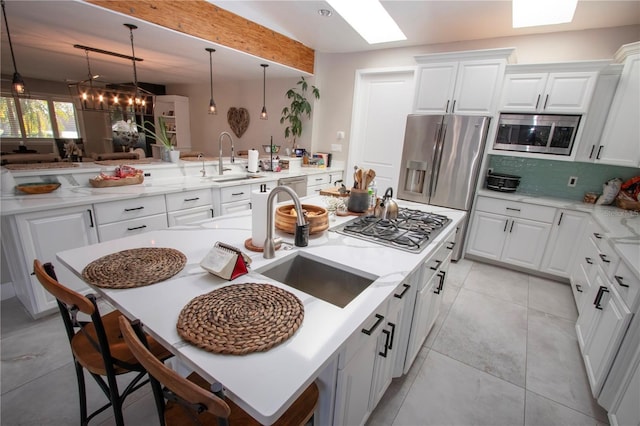 kitchen featuring tasteful backsplash, appliances with stainless steel finishes, kitchen peninsula, and white cabinets