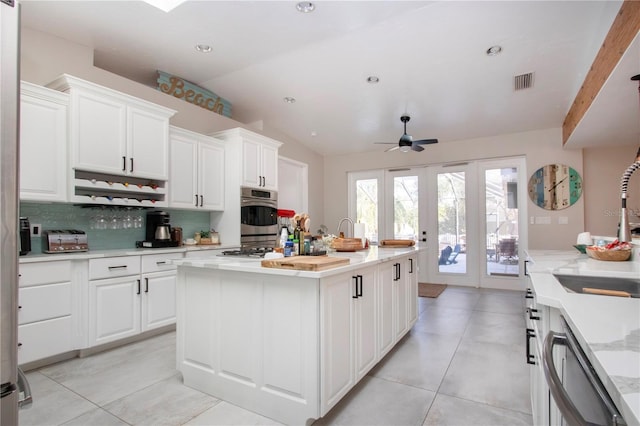 kitchen with white cabinetry, lofted ceiling, and a kitchen island