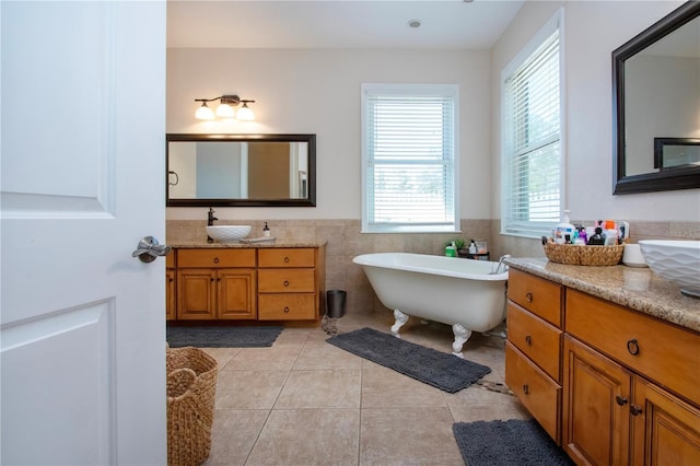 bathroom featuring tile patterned floors, a bathtub, tile walls, and a wealth of natural light