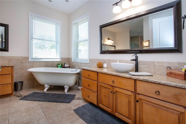 bathroom with tile patterned flooring, vanity, a bathtub, and tile walls