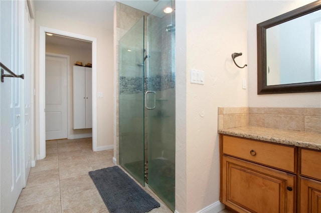 bathroom featuring tile patterned flooring, vanity, and a shower with shower door