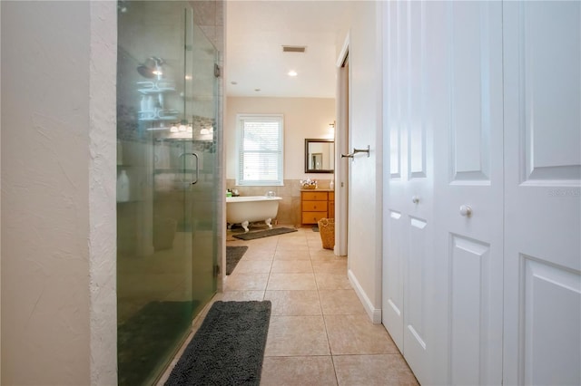 bathroom featuring tile patterned flooring, vanity, and shower with separate bathtub