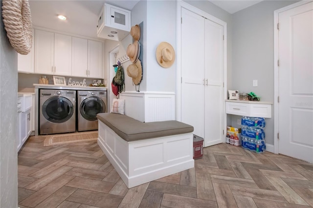 laundry area featuring cabinets, washer and clothes dryer, and light parquet floors