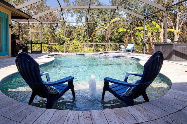 view of pool with an in ground hot tub, area for grilling, glass enclosure, and a patio